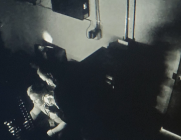 Covert, dark, blurred man sitting at desk